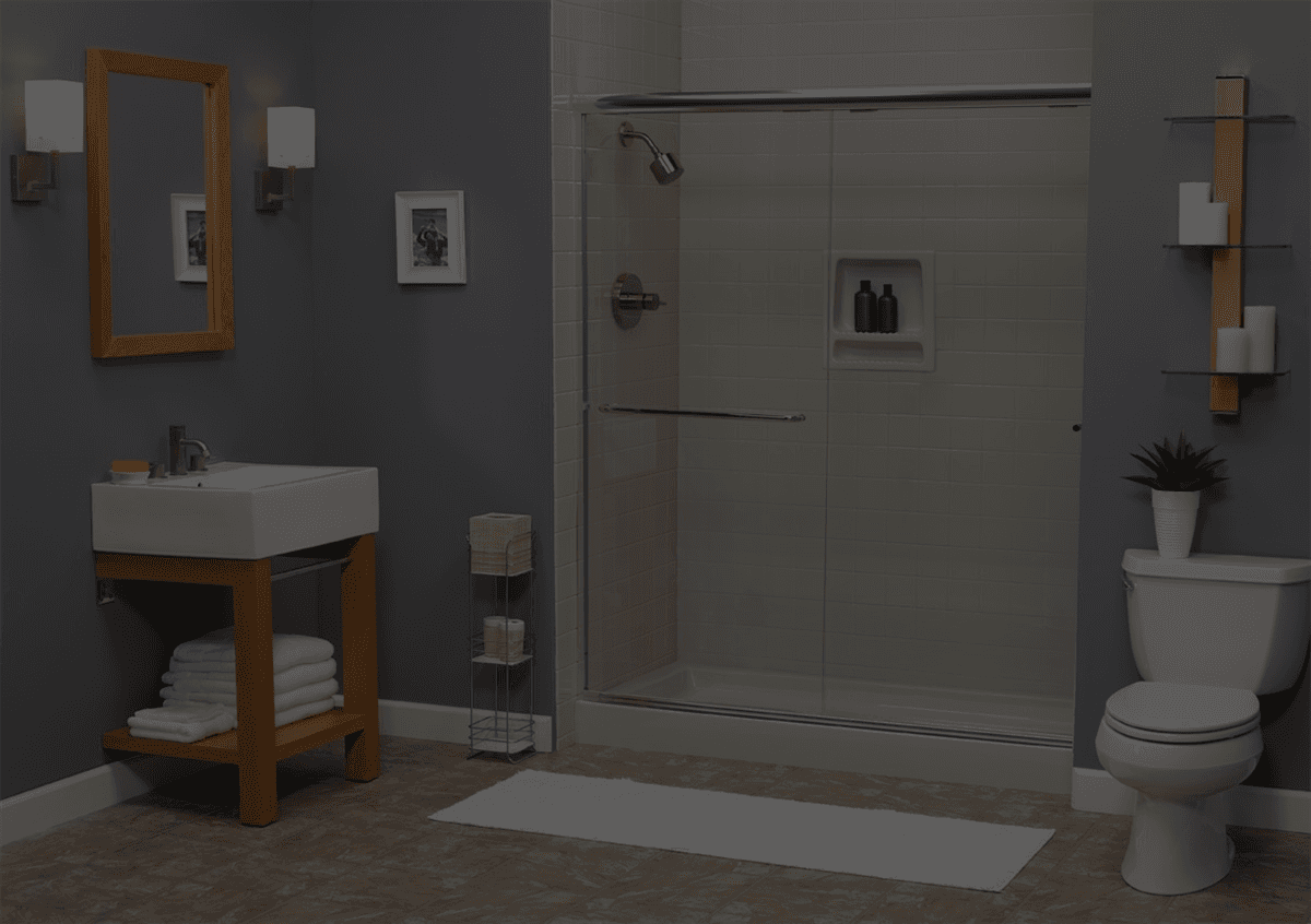 Modern bathroom with gray walls, glass shower, toilet, wooden vanity with sink, mirror, white towels, and shelves with candles and plant.