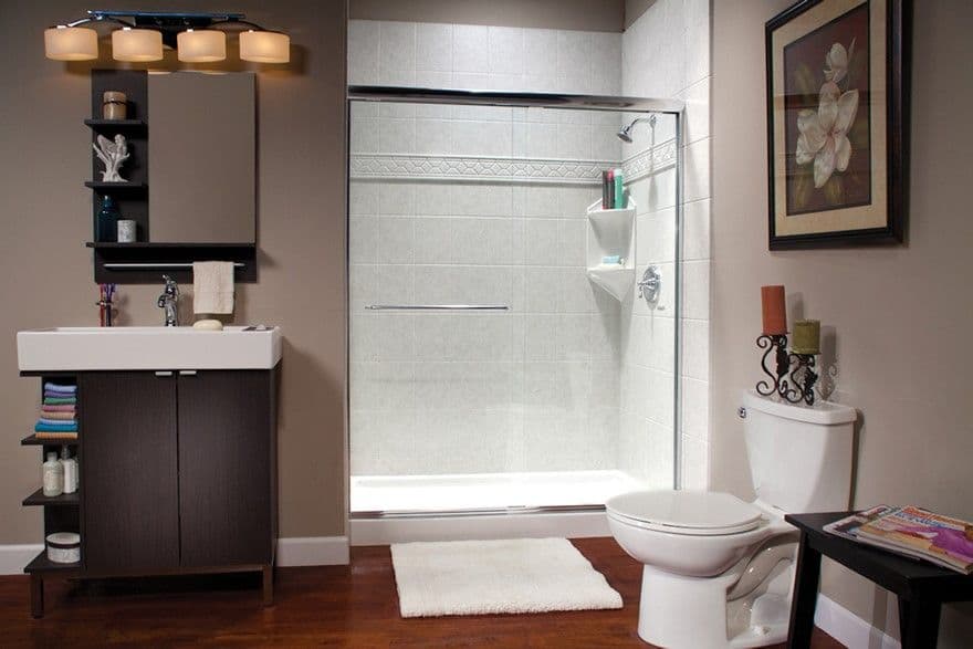 A mauve bathroom with a walk-in shower with white textured tile walls, corner shelves, and sliding glass doors.
