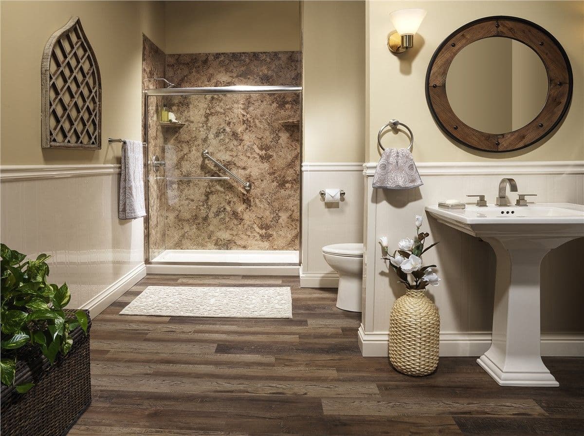 Elegant off-white bathroom with a marbled walk-in shower, pedestal sink, and wooden floor.